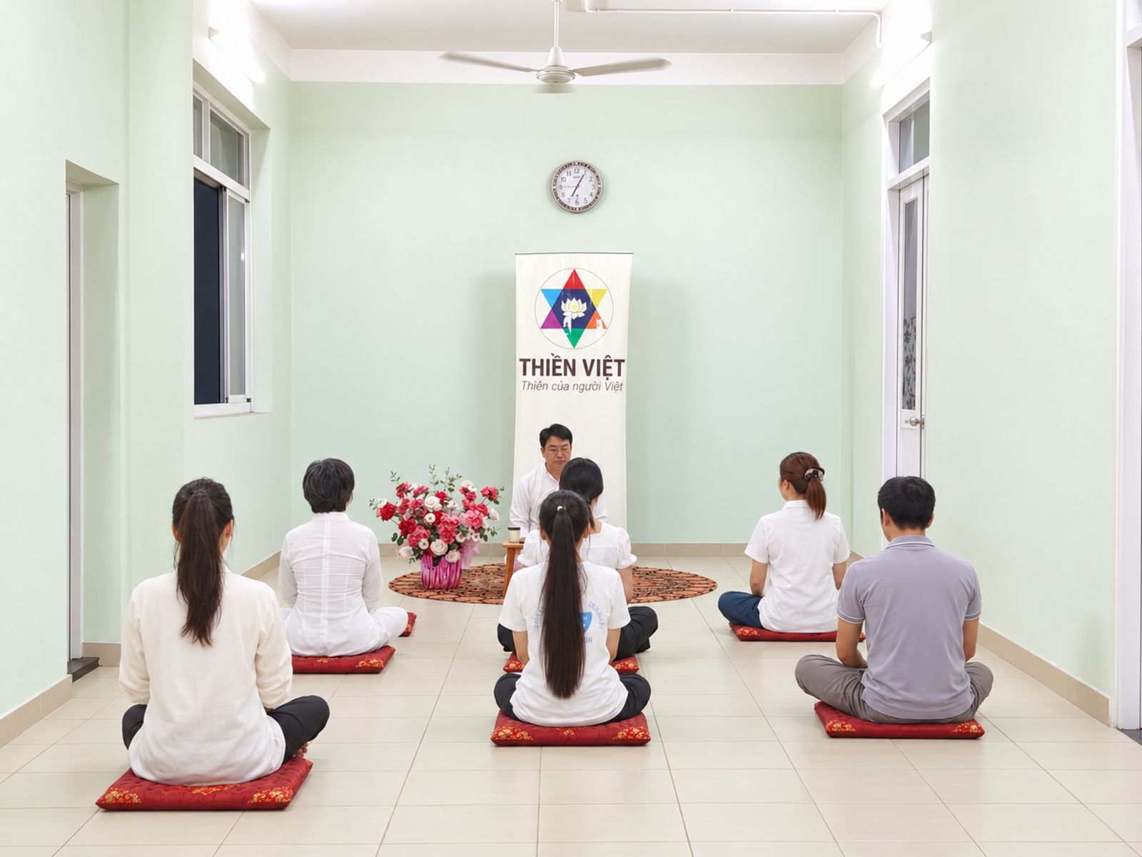 Lớp thiền ngồi hướng về banner Thiền Việt trong phòng tập